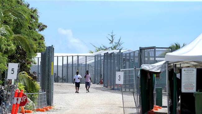 Daily Telegraph. Nauru Day 4.  2018 Pacific Islands Forum Nauru. Refugee men walk near the entry gate of detention camp 2 which houses single men.  Pic Nathan Edwards