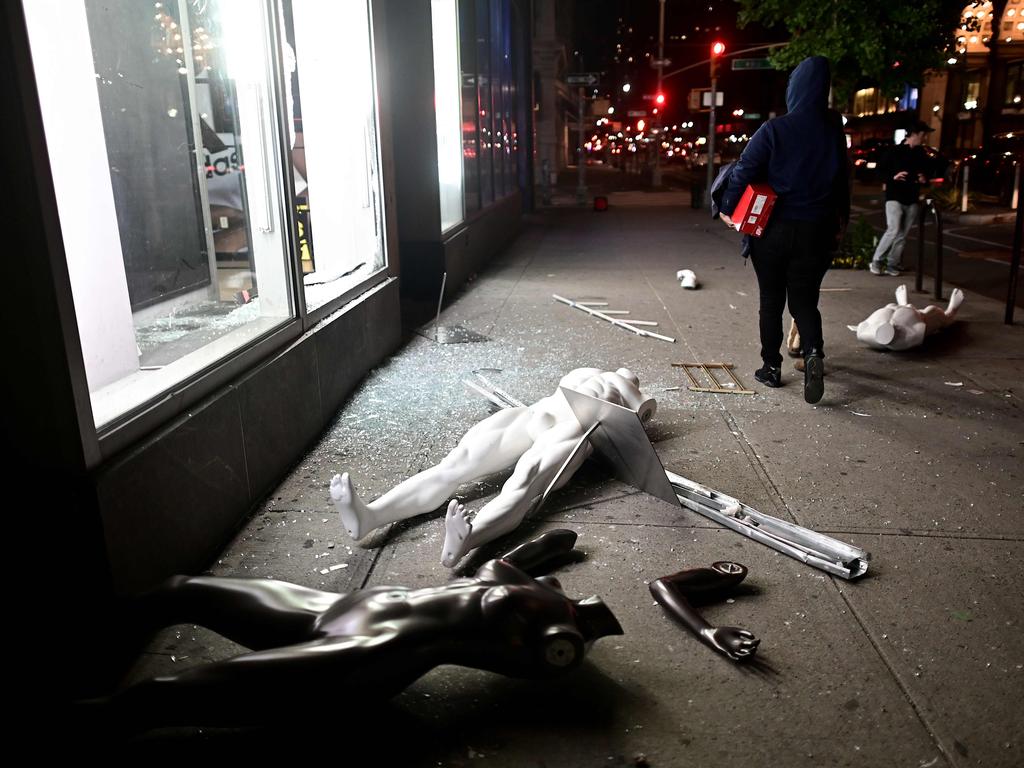 Looters walk next to a smashed store in Lower Manhattan. Picture: Johannes Eisele/AFP