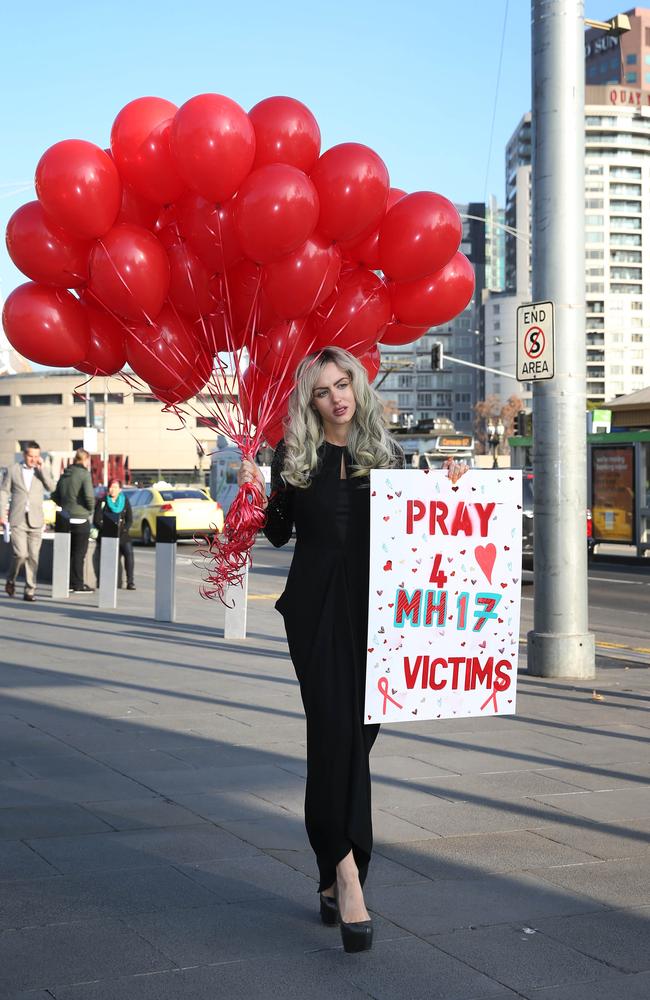 Gabi Grecko releases a small amount of red balloons at Federation Square in Melbourne, to honour the victims of the MH17 disaster.