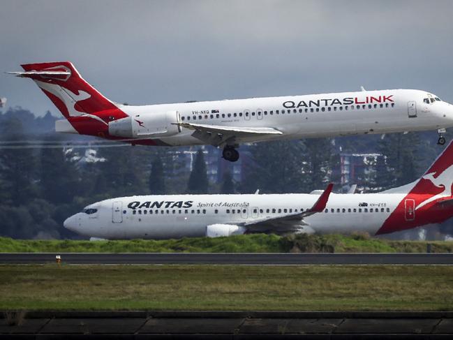 A Qantas Airlines Boeing 737-800 plane travels down the runway as a Qantas Boeing 717 plane lands at Sydney International Airport on June 7, 2024. (Photo by DAVID GRAY / AFP)