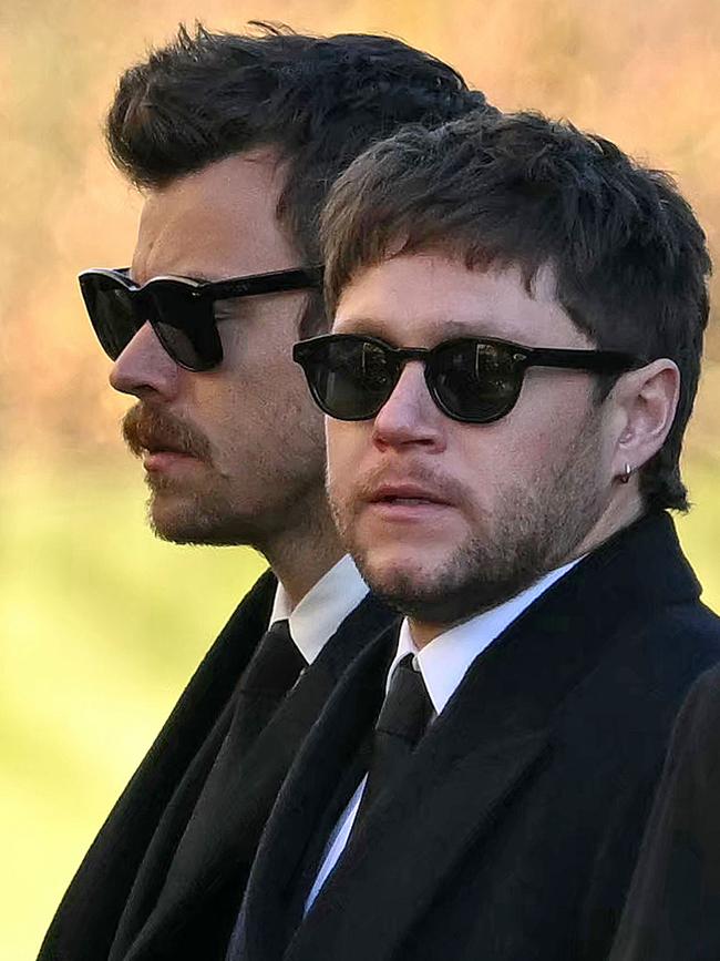 Former One Direction band members Harry Styles (L) and Niall Horan leave after attending the funeral.