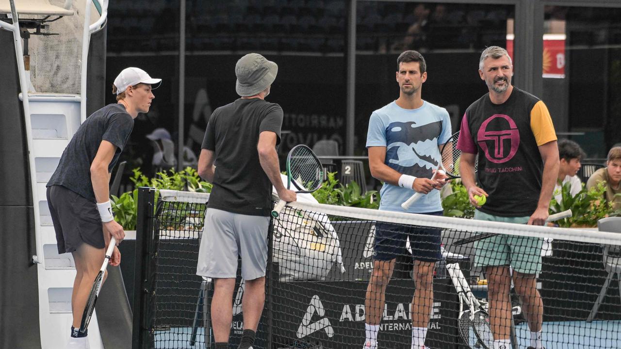 Novak Djokovic (2nd-R) talks with Italian tennis player Jannik Sinner (L), coach Darren Cahill (2nd-L) and his own coach Goran Ivanisevic (R) during a practice session on Friday. Picture: AFP