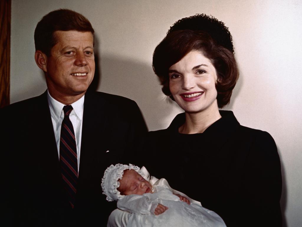 President John F. Kennedy with wife Jackie with son, John Jr. during his christening.