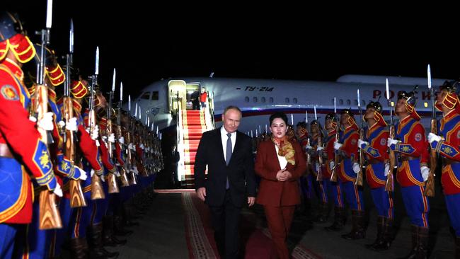 Vladimir Putin, accompanied by Battsetseg Batmunkh, Mongolia's Minister of Foreign Affairs, walks past honour guards upon arrival at the airport in Ulaanbaatar. Picture: AFP.