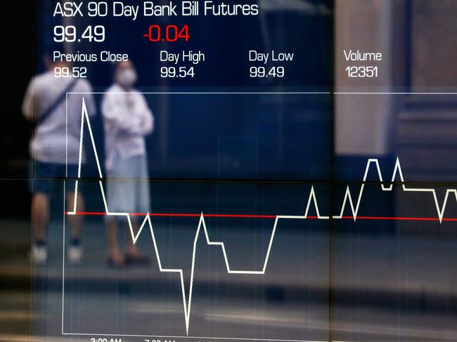 SYDNEY, AUSTRALIA - MARCH 19: A reflection of a woman wearing a mask is seen as an electronic board displays stock information at the Australian Securities Exchange, operated by ASX Ltd, on March 19, 2020 in Sydney, Australia. The Reserve Bank of Australia has cut official interest rates to a record low of 0.25% in a bid to protect the economy from the financial fallout of the global COVID-19 pandemic.  (Photo by Brendon Thorne/Getty Images)