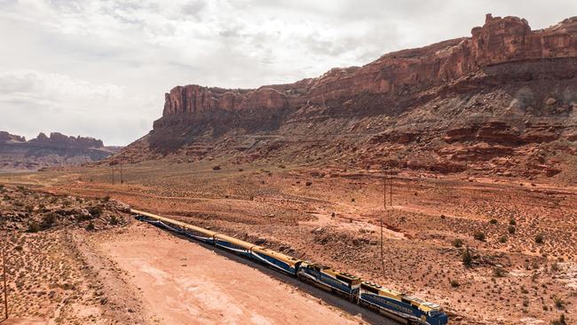 The journey takes passengers beside the red sandstone canyons of Moab, Utah.