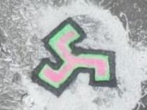 Pictures of the scene show a symbol similar to a “triskele” or three-pointed swastika daubed on a roadway. Picture: TNV