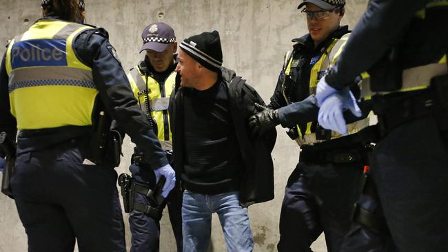 Police officers suround a man after he was evicted from the ground. Picture: David Caird