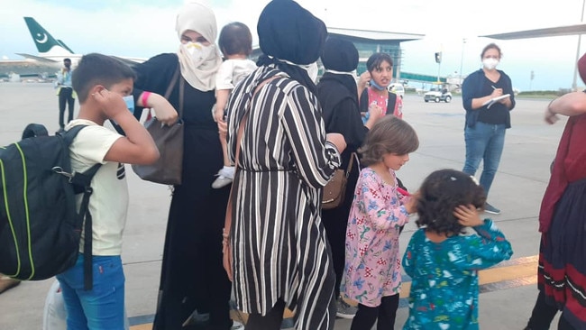 The group of 17, including orphans, staff and their children, board a plane to Australia from Islamabad, Pakistan. Picture: Supplied