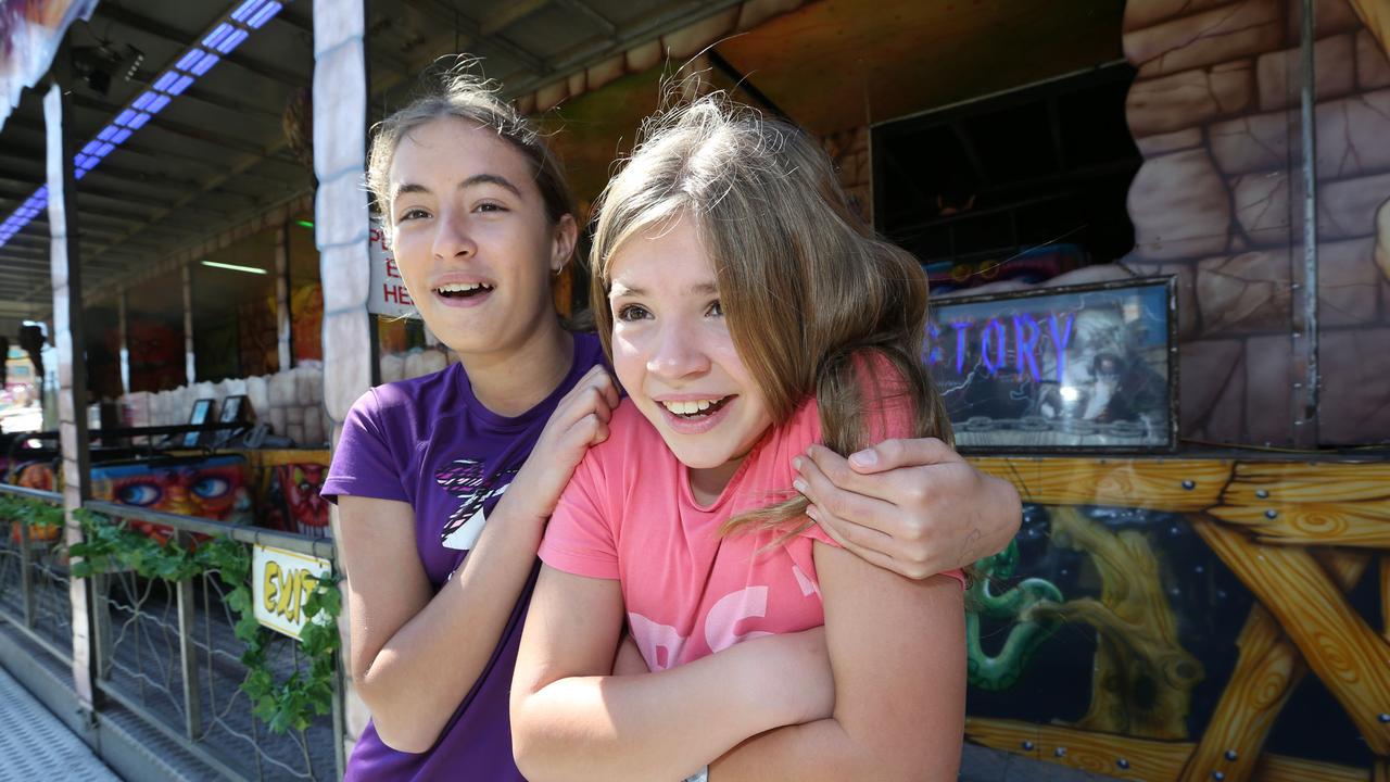 Lucy Wilson, 13, and her sister Matilda Wilson, 11, let go of their fears after the haunted house ride at the Gold Coast Show. Picture: Mike Batterham