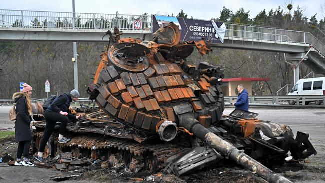 Residents check out a destroyed Russian tank on the outskirts of Buzova village, west of Kyiv, on Sunday. Picture: AFP