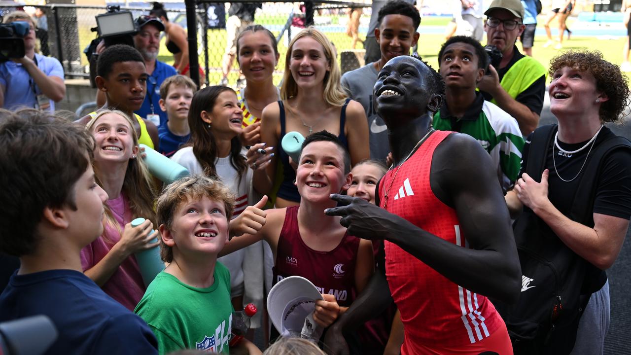 Gout Gout of Tigers Athletics Club takes photos with competitors and fans after winning the Men 100m Under 20 Finals. (Photo by Albert Perez/Getty Images)