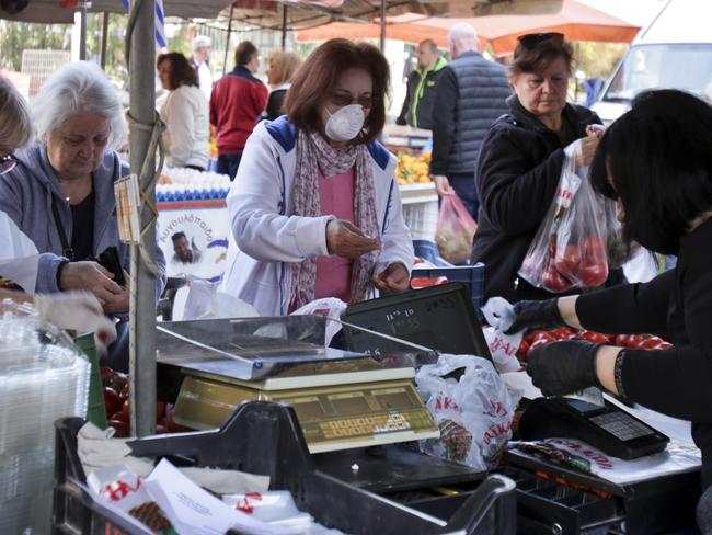 A woman wearing a face mask while shopping on green market in Athens, Greece. Picture: Getty