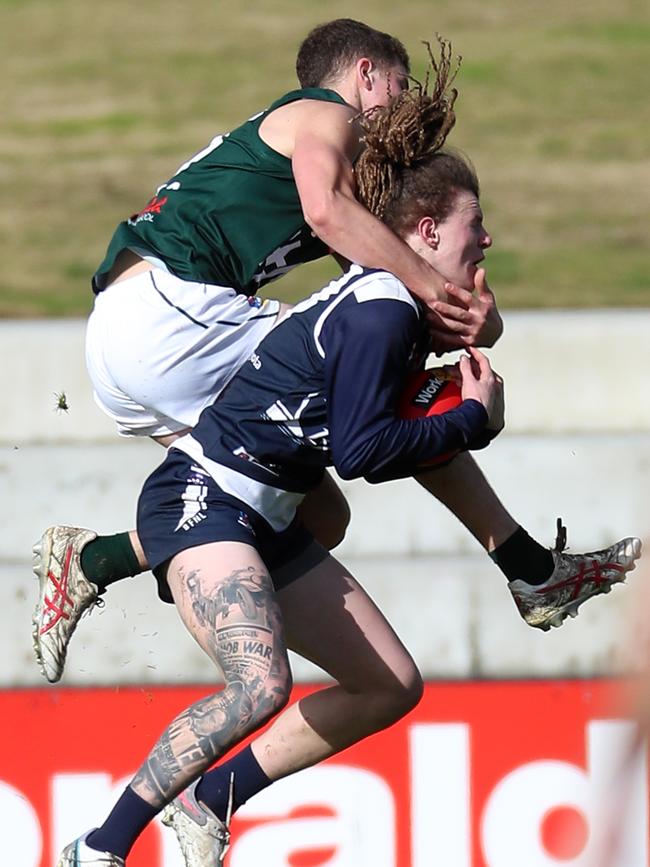 Hampden’s Toby Jennings gets in a high tackle against Ballarat’s Conrad Farruga. Picture Yuri Kouzmin
