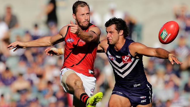 James Kelly gets his kick away under pressure from Brady Grey.