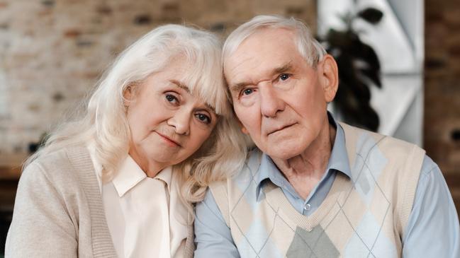 elderly couple hugging and sitting at home on quarantine; retirees, seniors generic