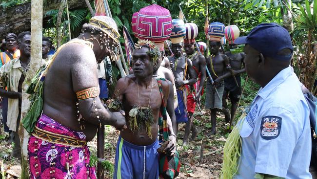 A Bougainville Referendum Commission returning officer, left, leads an Upe man to men-only polling station in the Bougainville referendum in Teau last month. Picture: AP