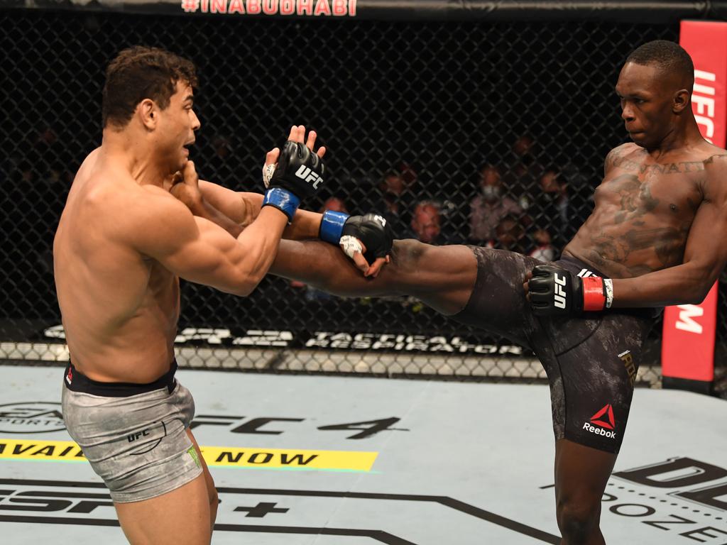 Israel Adesanya kicks Paulo Costa in their middleweight championship bout during UFC 253.