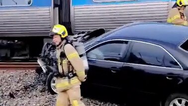 The driver was rescued before his car was struck by a train.