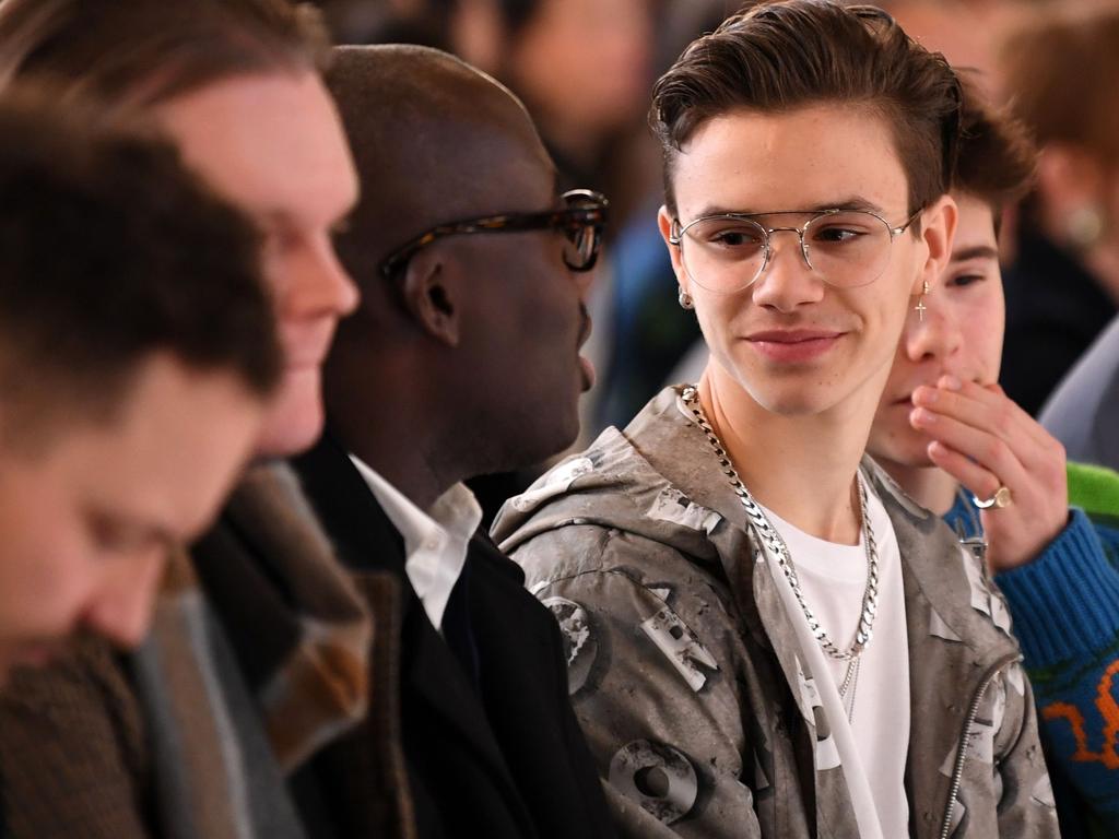 British Vogue editor Edward Enninful (Centre Left) in the front row with the Beckhams. Picture: AFP