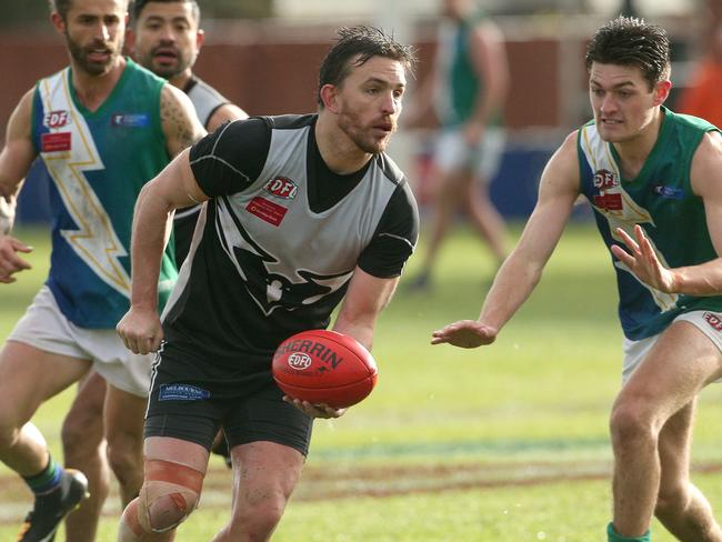 Roxburgh Park coach Michael Farrelly looks to fire off a handball. Picture: Hamish Blair