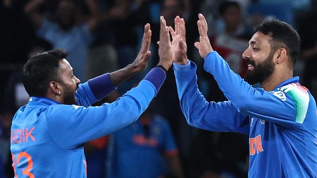 India's Varun Chakravarthy (R) celebrates with teammate Hardik Pandya after taking the wicket of New Zealand's Matt Henry during the ICC Champions Trophy one-day international (ODI) cricket match between New Zealand and India at the Dubai International Stadium in Dubai on March 2, 2025. (Photo by FADEL SENNA / AFP)