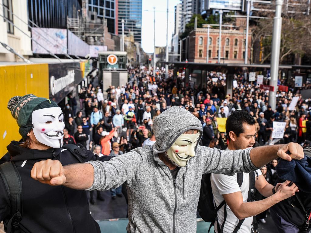 Men wearing Anonymous masks during the protest in Sydney. Picture: NCA NewsWire/Flavio Brancaleone