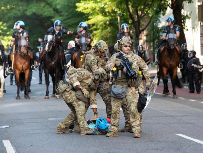 Military police officers restrain a protester near the White House. Picture: AFP