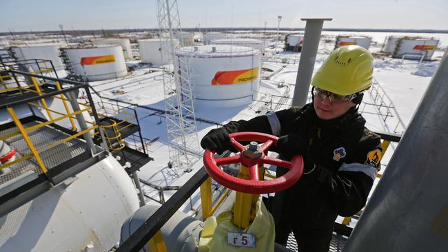 A worker turns a flow valve near oil storage tanks at a pumping station, operated by Rosneft. Picture: Andrey Rudakov/Bloomberg