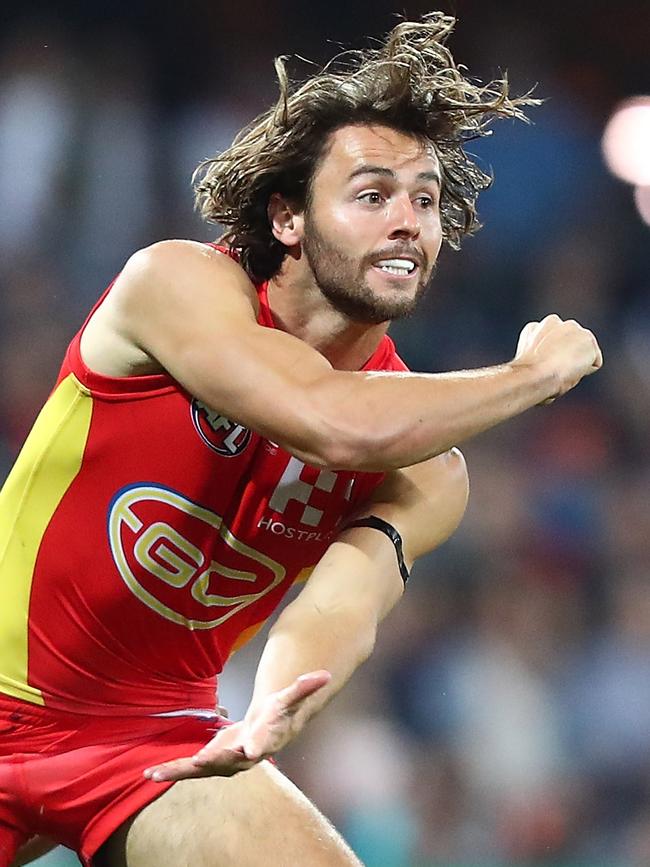 Lachie Weller fires off a handball against Carlton.