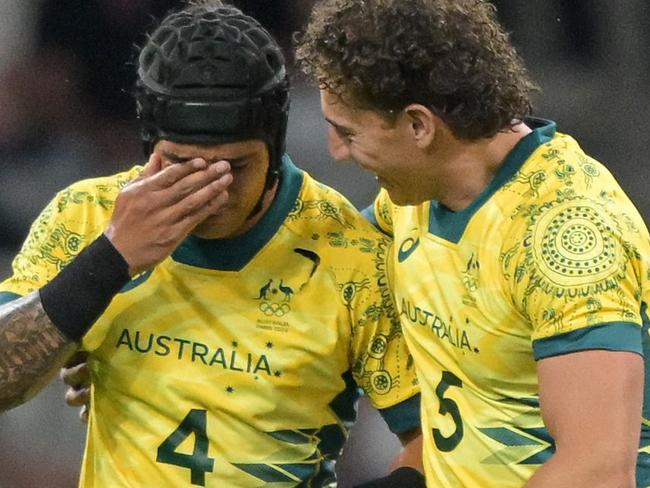 Australia's Dietrich Roache (L) and Australia's Mark Nawaqanitawase (R) clebrate after Australia won the men's quarter final rugby sevens match between Australia and USA during the Paris 2024 Olympic Games at the Stade de France in Saint-Denis on July 25, 2024. (Photo by CARL DE SOUZA / AFP)