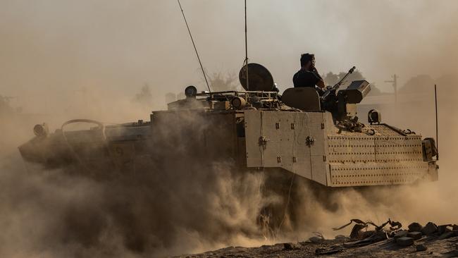 An armored personnel carrier kicks dust up as it moves through a field near the Gaza border in Southern Israel. Picture: Alexi J. Rosenfeld/Getty Images