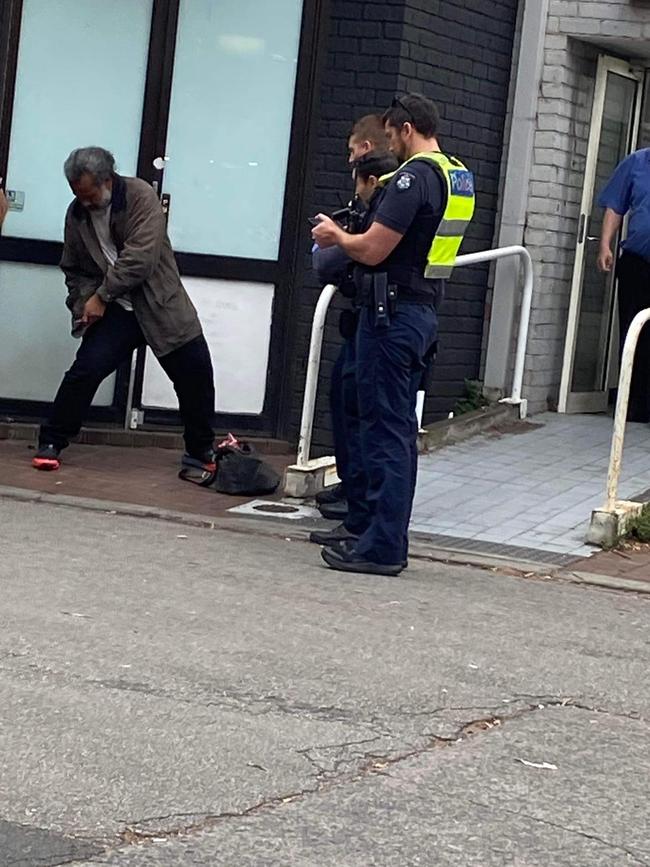 Police attempt to move along a man with no fixed address on Carlisle St in St Kilda. Picture: Supplied