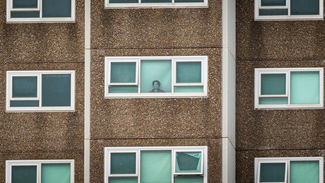 A lone woman is seen looking out the window of her apartment at the North Melbourne Public housing flats on July 5, 2020 in Melbourne. Picture: Asanka Ratnayake/Getty Images