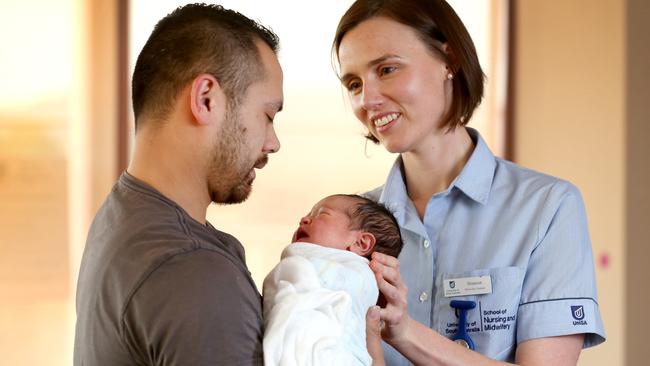 Midwifery student Shannon Harrison helps new father Charles Mitchell with daughter Emily. Picture: AAP/Dean Martin