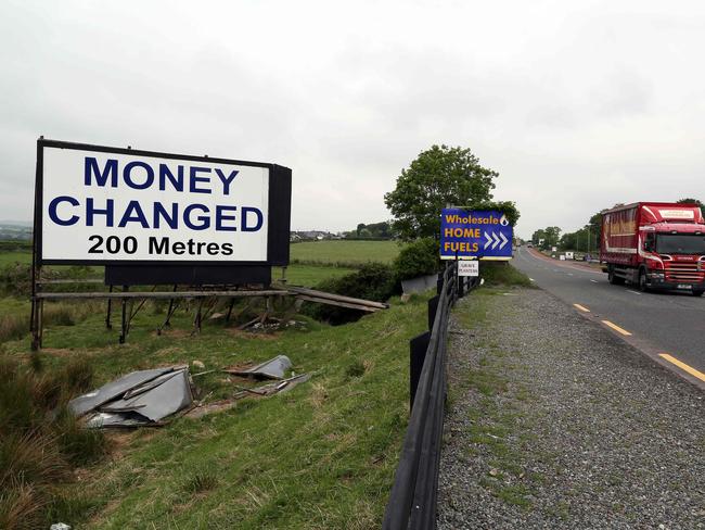 A "money exchanged" sign is pictured at the border between Newry in Northern ireland and Dundalk in The Republic of Ireland on June 7, 2016. The border that divides the island of Ireland is now invisible, with just a few crumbling former customs buildings serving as reminders of a bygone era of a hard frontier between north and south. All of this could be about to change. In the event of a Brexit on June 23, these 500 kilometres (311 miles) would become the sole land border between the United Kingdom and the European Union and there are genuine concerns that this will mean the reintroduction of customs barriers that were abolished on January 1, 1993 - and even immigration controls for the first time. / AFP PHOTO / PAUL FAITH