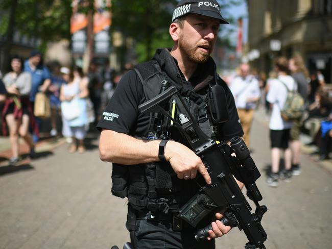 Armed police patrol as members of the public queue to lay flowers in St Ann's Square in memory of those who lost their lives in the Manchester Arena attack on May 25. Picture: Jeff J Mitchell/Getty Images