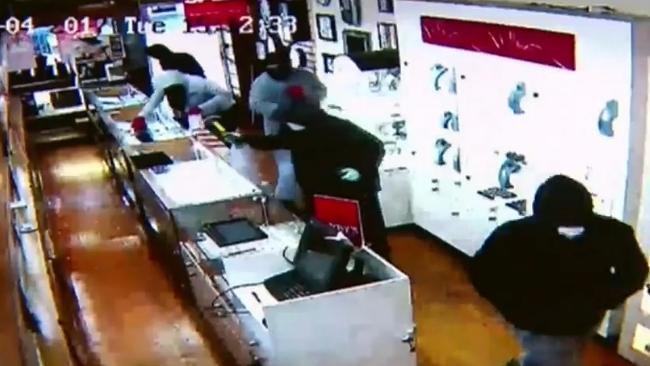 A masked robber uses a hammer to steal from the Elsternwick jewellery store. Picture: Channel 9.