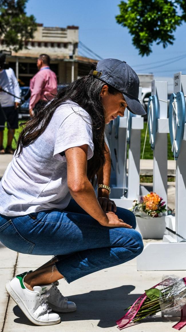 Meghan Markle places flowers as she mourns at a makeshift memorial outside Uvalde County Courthouse in Texas.