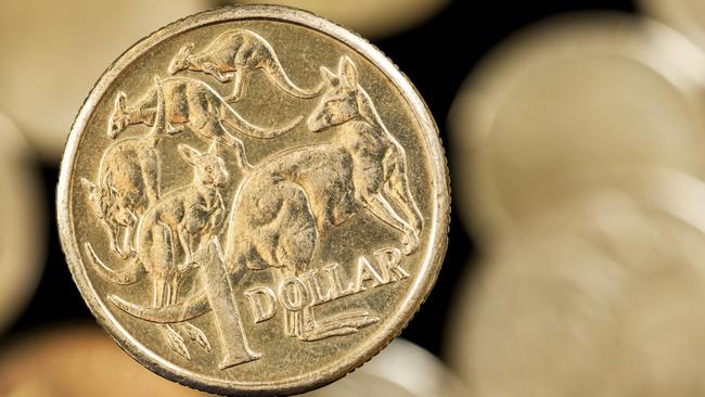 Australian one dollar coin over blurred golden background.