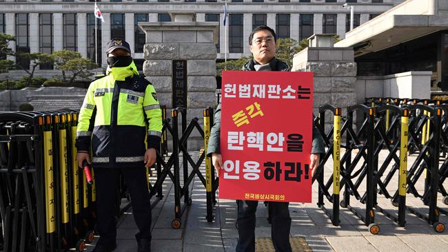 A man criticising South Korea's President Yoon Suk Yeol holds a placard reading "The Constitutional Court must immediately accept the impeachment motion!" in front of the Constitutional Court in Seoul. Picture: Jung Yeon-je / AFP