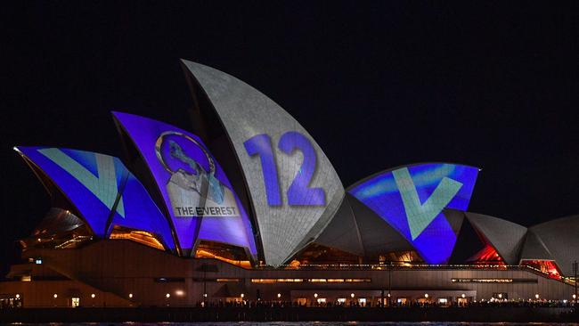 A protest with torches and other lights interrupts the barrier draw results for The Everest as they are projected onto the sails of the Opera House tonight. Picture: AAP/Brendan Esposito