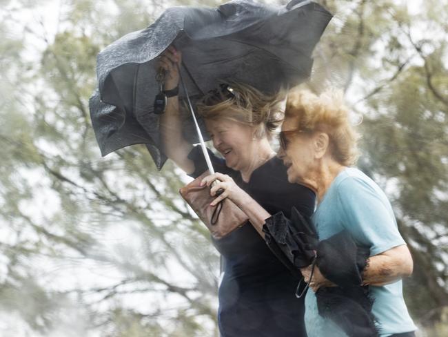 Morning walkers at Mooloolaba as the weather deteriorates as ex-tropical cyclone Alfred crosses the coast. Picture Lachie Millard