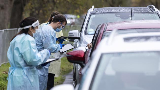 Staff wearing PPE are seen amongst massive queues at a pop-up COVID test site at Albert Park Lake in Melbourne. Picture: Getty