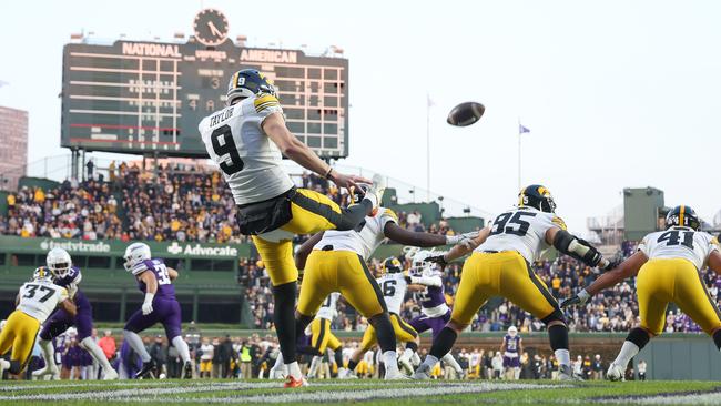 Tory Taylor punting against the Northwestern Wildcats. (Photo by Michael Reaves/Getty Images)