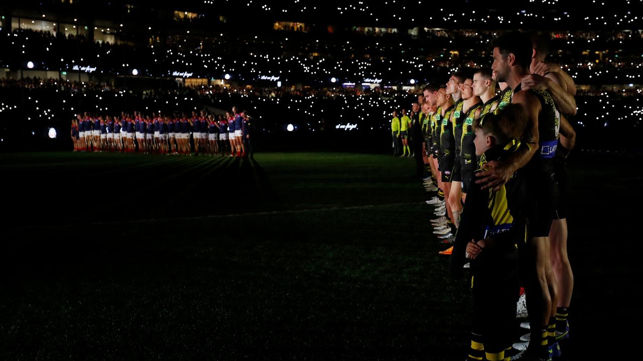 Players line up during the Anzac observance ceremony under darkness. Picture: Dylan Burns/AFL Photos via Getty Images