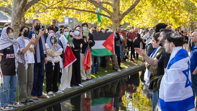 Pro-Palestine and pro-Israel protesters facing off over a pond at Melbourne University. Picture: Jason Edwards