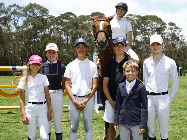 DAILY TELEGRAPH DECEMBER 8, 2024. Magic Millions ambassador Ally Mosley and competitors will be vying for a position in the Qld Off the Track Cup final showjumping event which will be held in January on the Gold Coast. Ally Mosley with horse Gerry and junior showjumpers from left Iliana Hercus, Evie Magnier, Alexander Jang, Charlie Magnier, Rhys McEvoy and Hannah Doolan at the Sydney International Equestrian Centre. Picture: Jonathan Ng