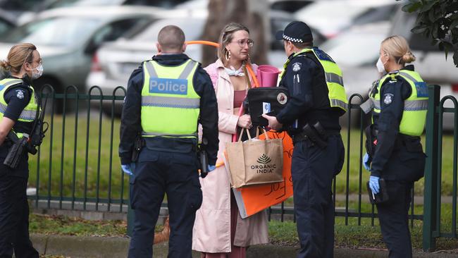 A protester is ordered to leave the area around the towers in Flemington. Picture: Josie Hayden.