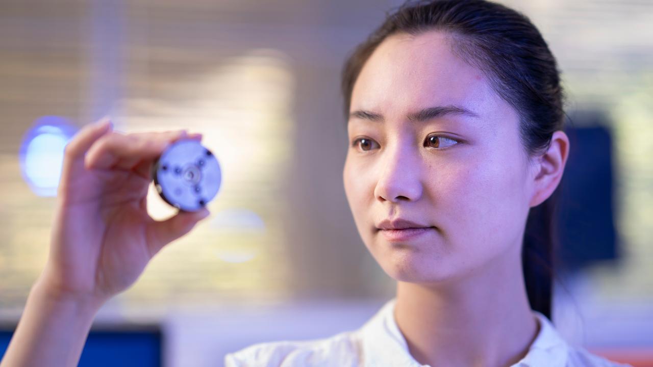 Xingshuo Huang with a sample of laboratory-made diamond in a metal case. Picture: Jamie Kidston/ANU